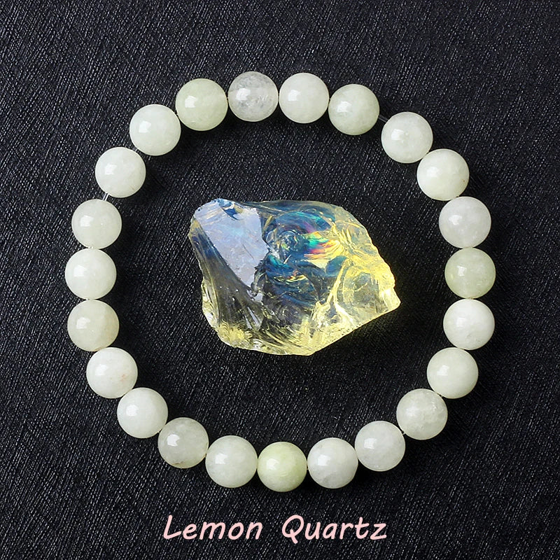 Lemon Quartz bracelet with soft pale yellow beads surrounding a raw golden iridescent quartz crystal on dark background