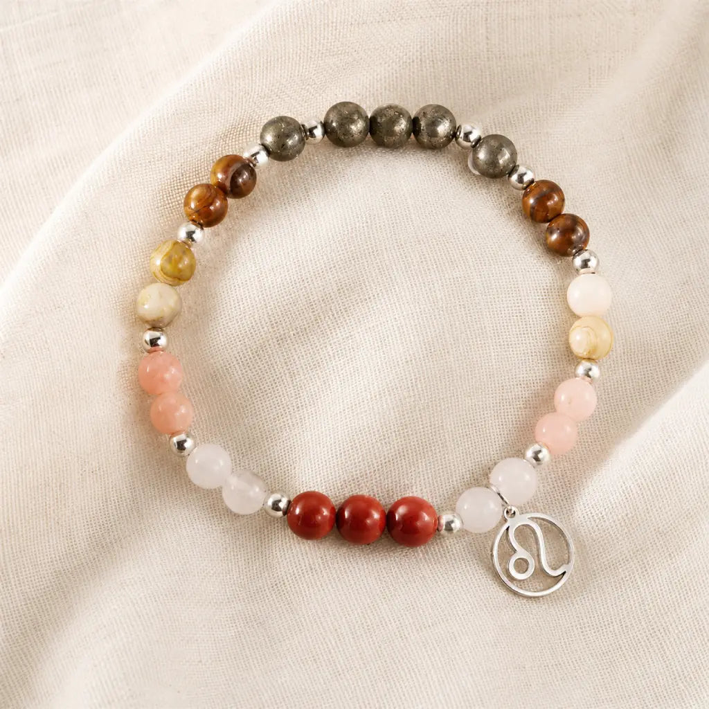 Leo crystal jewelry with healing gemstones and zodiac charm arranged on soft fabric for elegant product presentation.