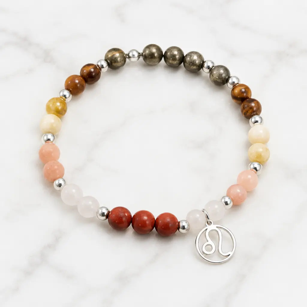 Leo crystal jewelry bracelet with natural healing gemstones and zodiac charm displayed on elegant marble background.