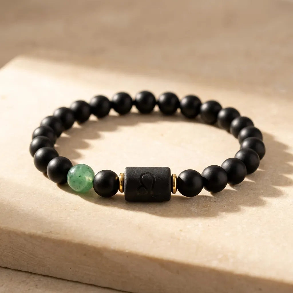 Leo zodiac bracelet with matte black beads and green gemstone on natural stone surface, premium astrology jewelry for confident style