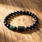 Leo zodiac bracelet with black beads and green gemstone on wood, natural style jewelry for bold confident zodiac expression