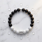 Black and white beaded bracelet on a marble surface with clear crystals.