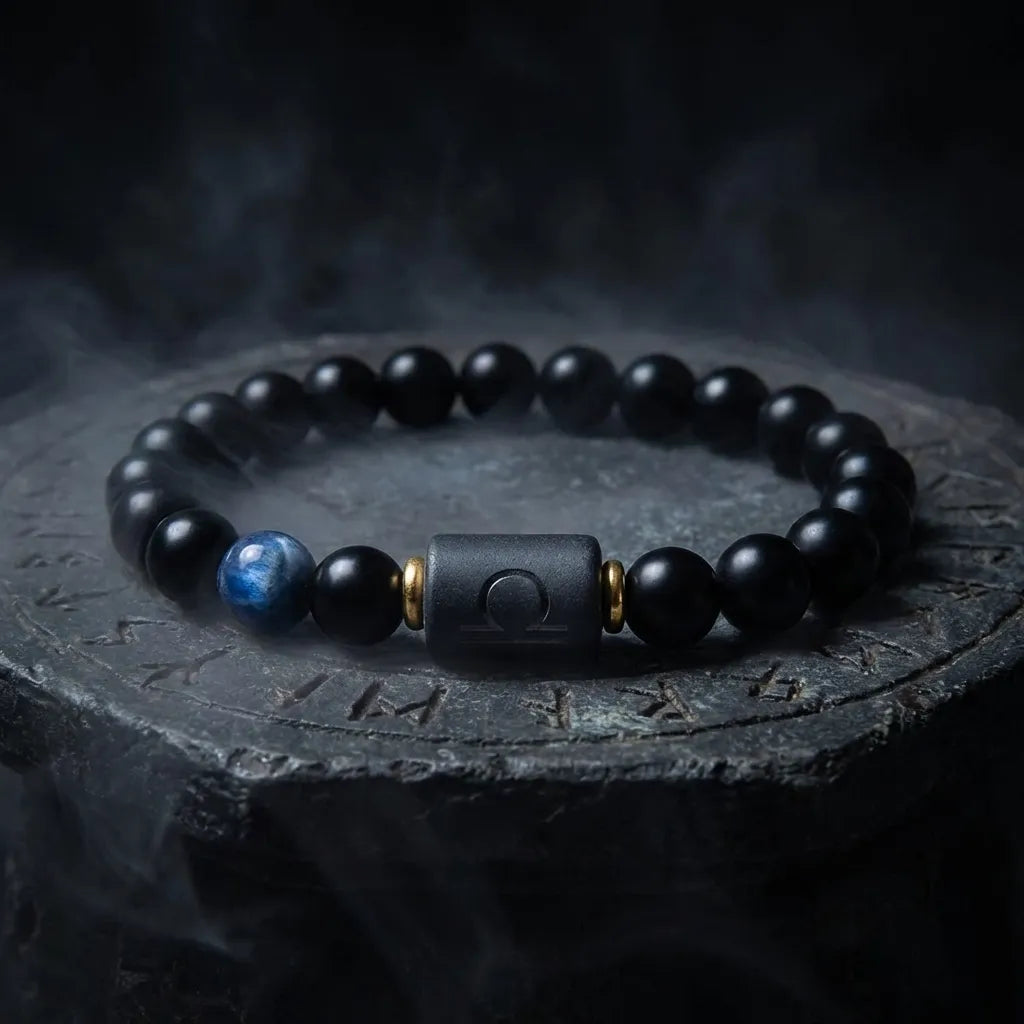 Libra zodiac bracelet with matte black beads, blue accent stone, and engraved center bead on clean white background