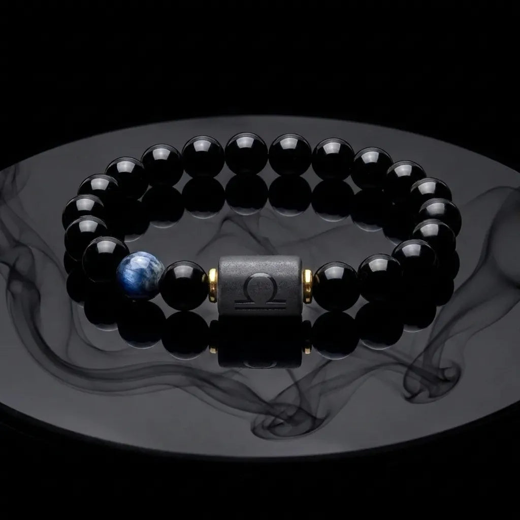 Libra zodiac bracelet with glossy black beads, blue accent stone, and engraved center bead with smoke reflection.