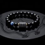 Libra zodiac bracelet with glossy black beads, blue accent stone, and engraved center bead with smoke reflection.