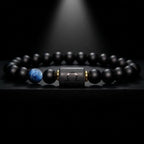 Libra zodiac bracelet with matte black beads, blue accent stone, and engraved center bead under spotlight.