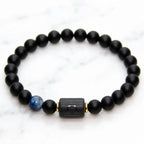 Libra zodiac bracelet with matte black beads, blue accent stone, and engraved center bead on white background.