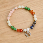 Libra zodiac Jewelry bracelet with colorful gemstones and silver Libra charm displayed on natural wood background