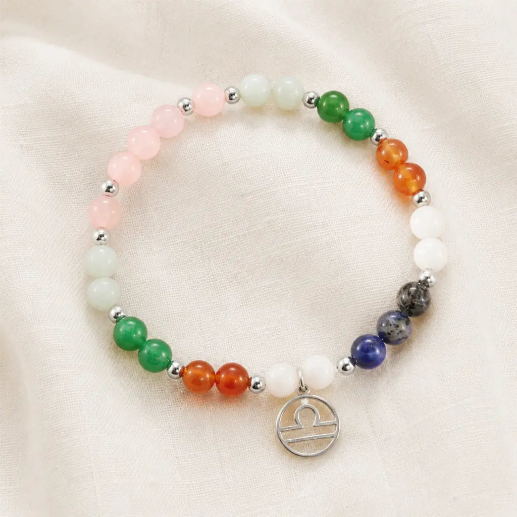 Libra zodiac Jewelry arranged on soft fabric showcasing multicolor gemstone beads and Libra symbol charm elegance