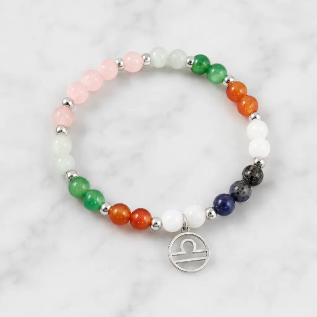Libra zodiac Jewelry showcased on marble background featuring colorful gemstone beads and elegant Libra symbol charm