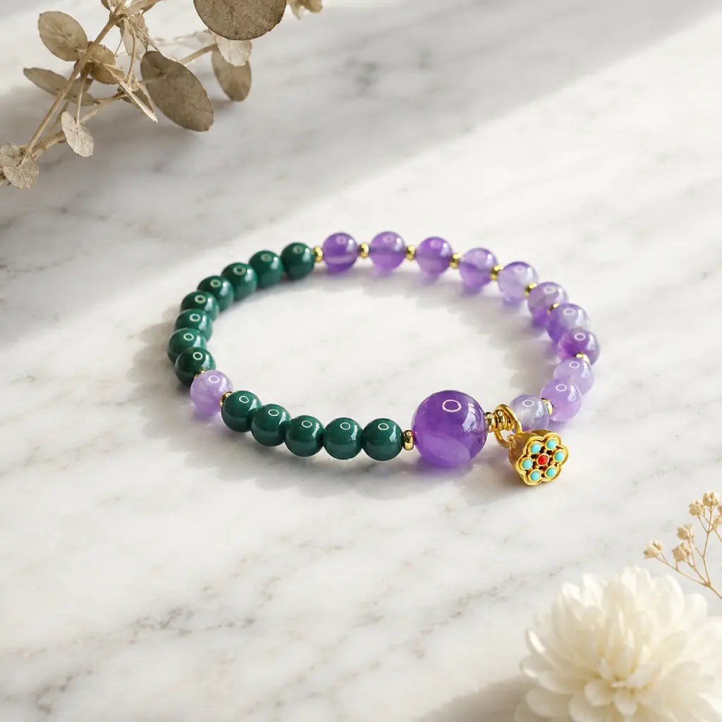 Lotus bracelet with purple crystal and green gemstone beads displayed elegantly for mindful energy wear