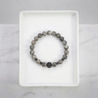 map jasper bracelet centered on white tray with gray beads and black accent, clean minimalist jewelry for modern style