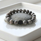 map jasper bracelet displayed on smooth river stone, gray natural beads for grounded mindful everyday wear style