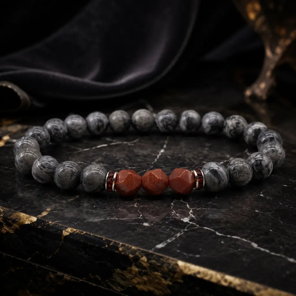 Map stone jasper bracelet with polished gray round beads and red faceted stones on black marble for luxe focus