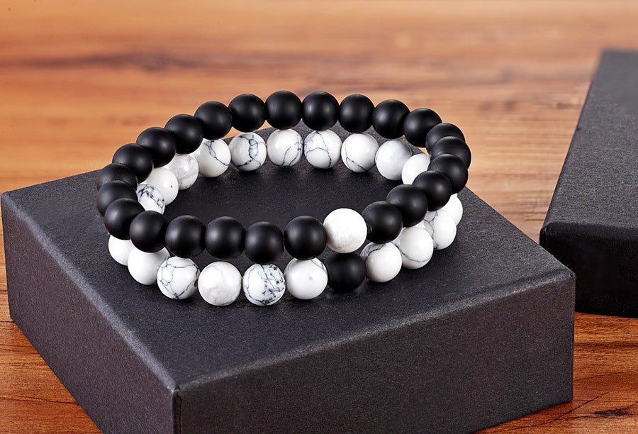 Matching bead bracelets for couples displayed as two coordinated glass-bead strands, pairing matte black round beads with white marbled round beads on a black gift box as one pair.