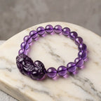 Natural amethyst bracelet on marble platform with healing crystal beads and elegant gemstone design