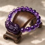 Natural amethyst bracelet on wooden display featuring polished purple beads and spiritual crystal charm