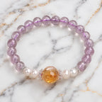 Natural ametrine citrine bracelet with polished gemstone beads and pearl accents on marble display.