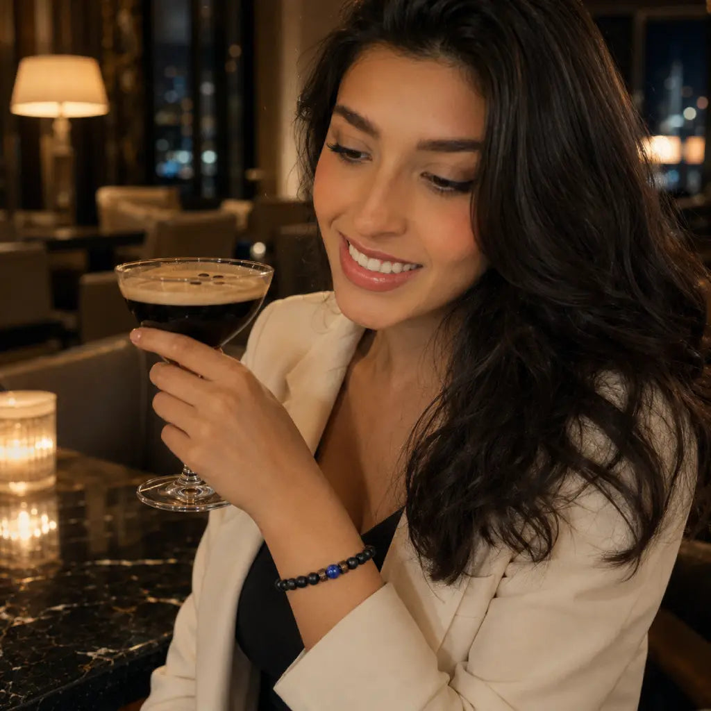 Natural stone lapis lazuli black onyx bracelet on woman at luxury hotel bar with espresso martini, healing crystal beaded jewelry trendy 2026

