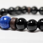 Obsidian lapis lazuli bracelet featuring a vibrant blue gemstone centerpiece with polished black beads and artisan craftsmanship.
