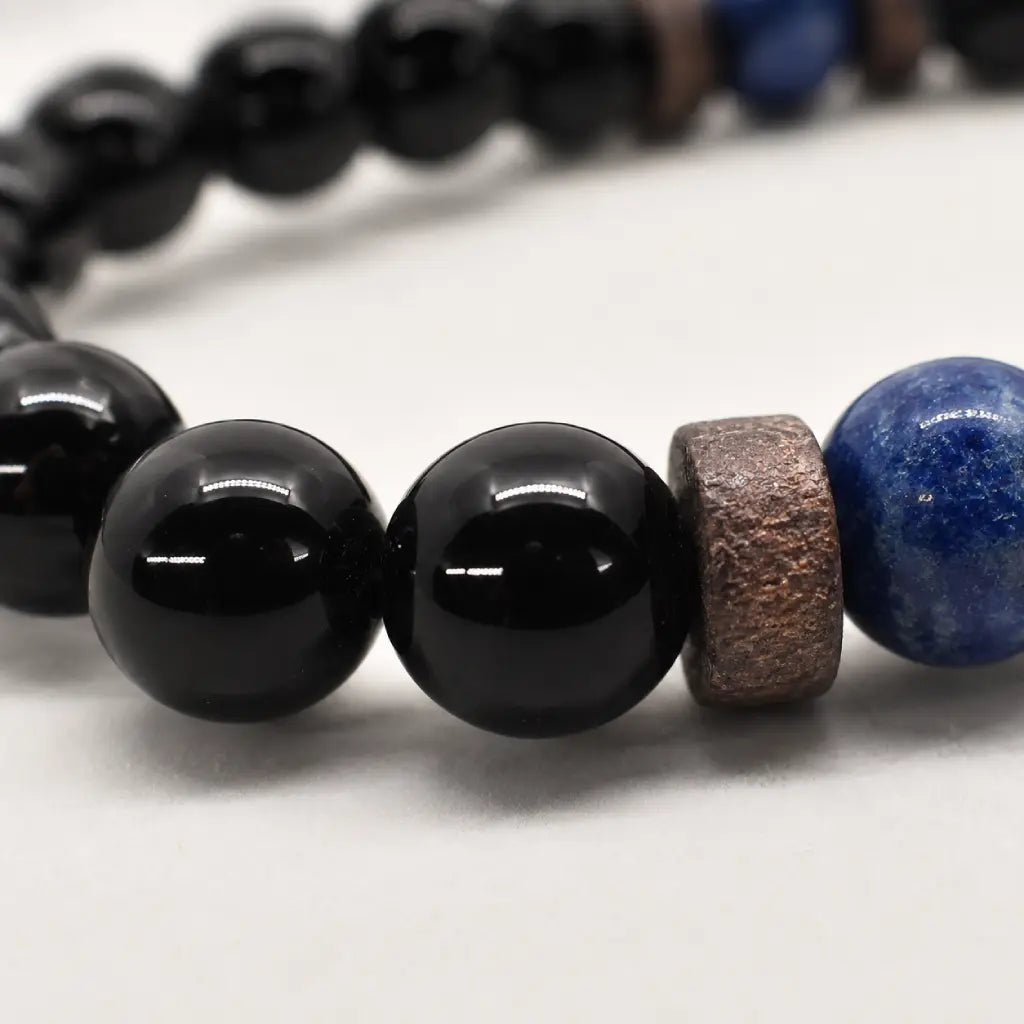 Obsidian lapis lazuli bracelet close-up highlighting glossy black gemstone beads and handcrafted wood spacers for premium quality.