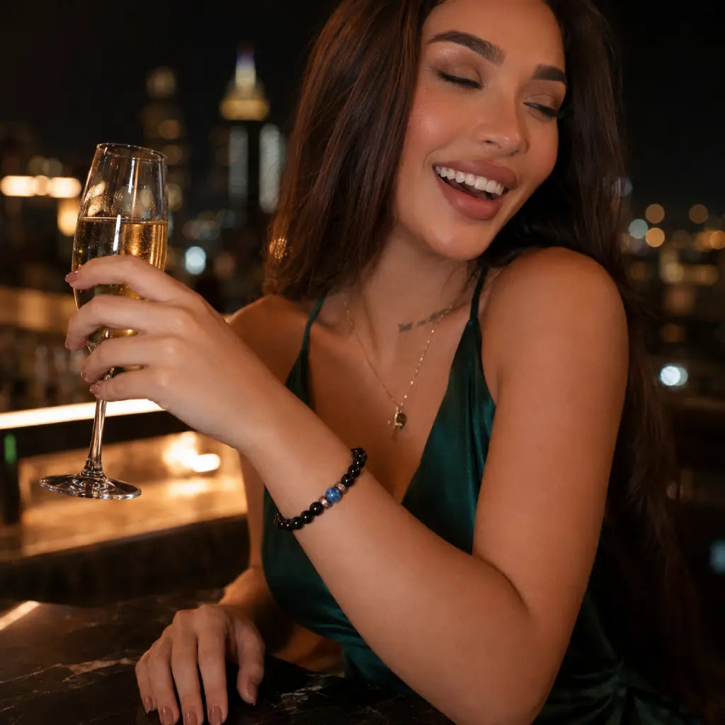 Obsidian lapis lazuli bracelet paired with champagne and evening attire, showcasing polished gemstone beads for luxury appeal.