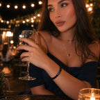 Obsidian lapis lazuli bracelet worn with an elegant blue dress and wine glass, featuring polished gemstone beads for upscale style.
