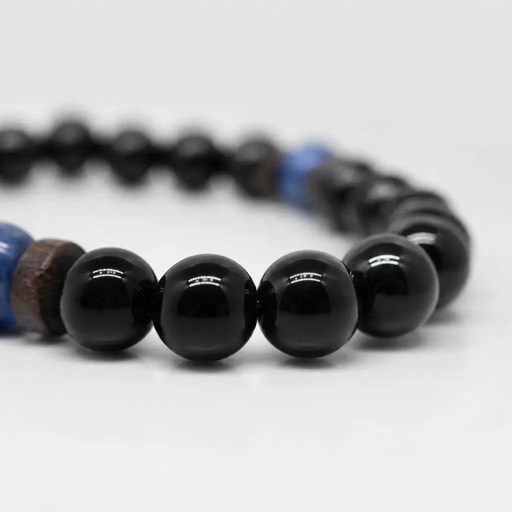 Obsidian lapis lazuli bracelet product view showcasing polished black gemstone beads with a natural blue stone centerpiece.