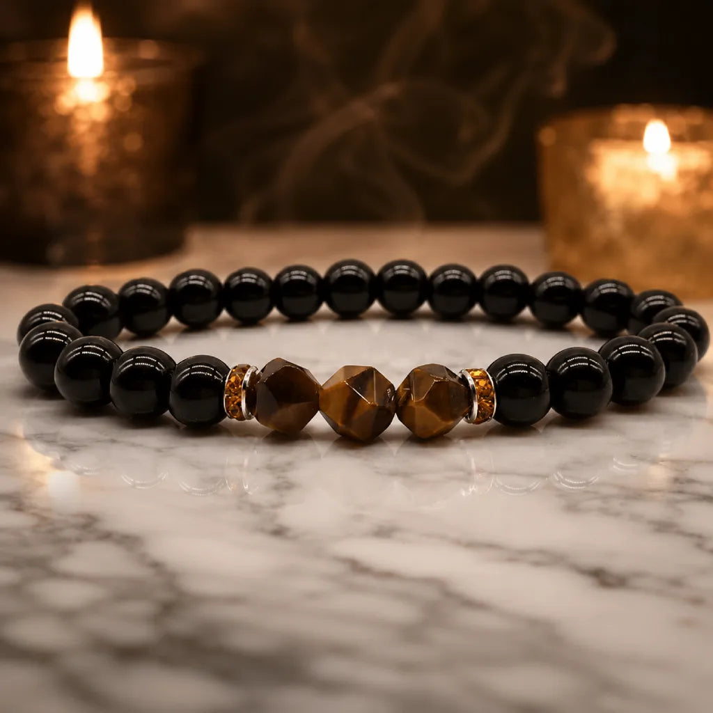 Obsidian tiger eye crystal bracelet on marble surface, grounding gemstone jewelry for inner balance