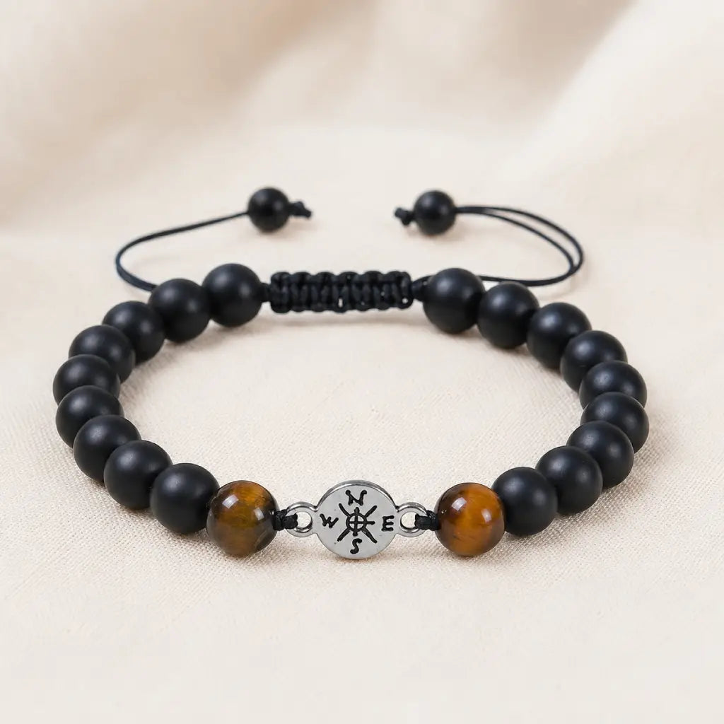 Onyx and Tiger eye bracelet with smooth black beads and polished stones displayed on soft neutral fabric.