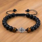 Onyx and Tiger eye bracelet with adjustable cord and matte black beads styled on warm wooden surface.