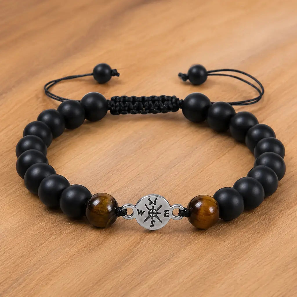 Onyx and Tiger eye bracelet with adjustable cord and matte black beads styled on warm wooden surface.
