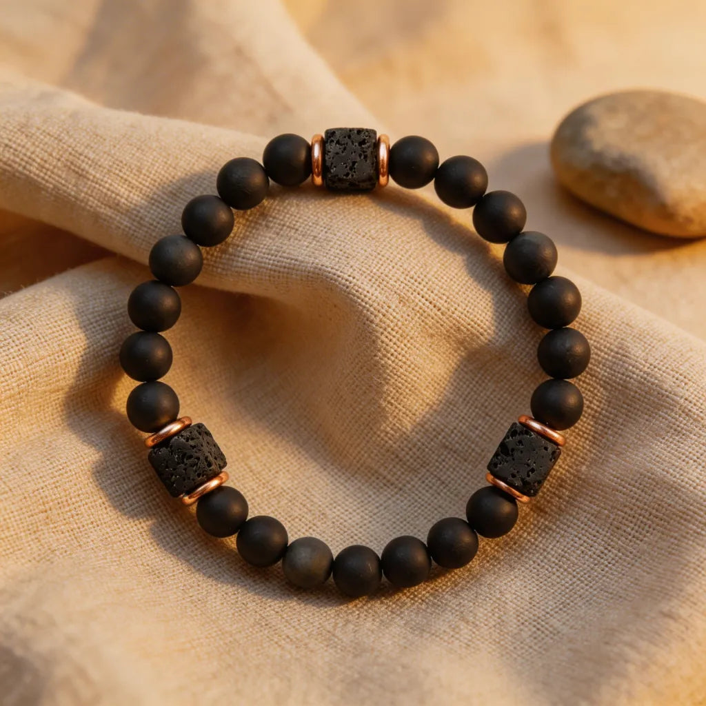 Black beaded bracelet with lava rock accents on a beige fabric background