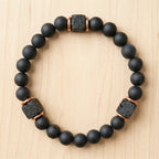 Onyx lava bracelet on light wood with matte black beads and lava stone spacers for grounding spiritual style