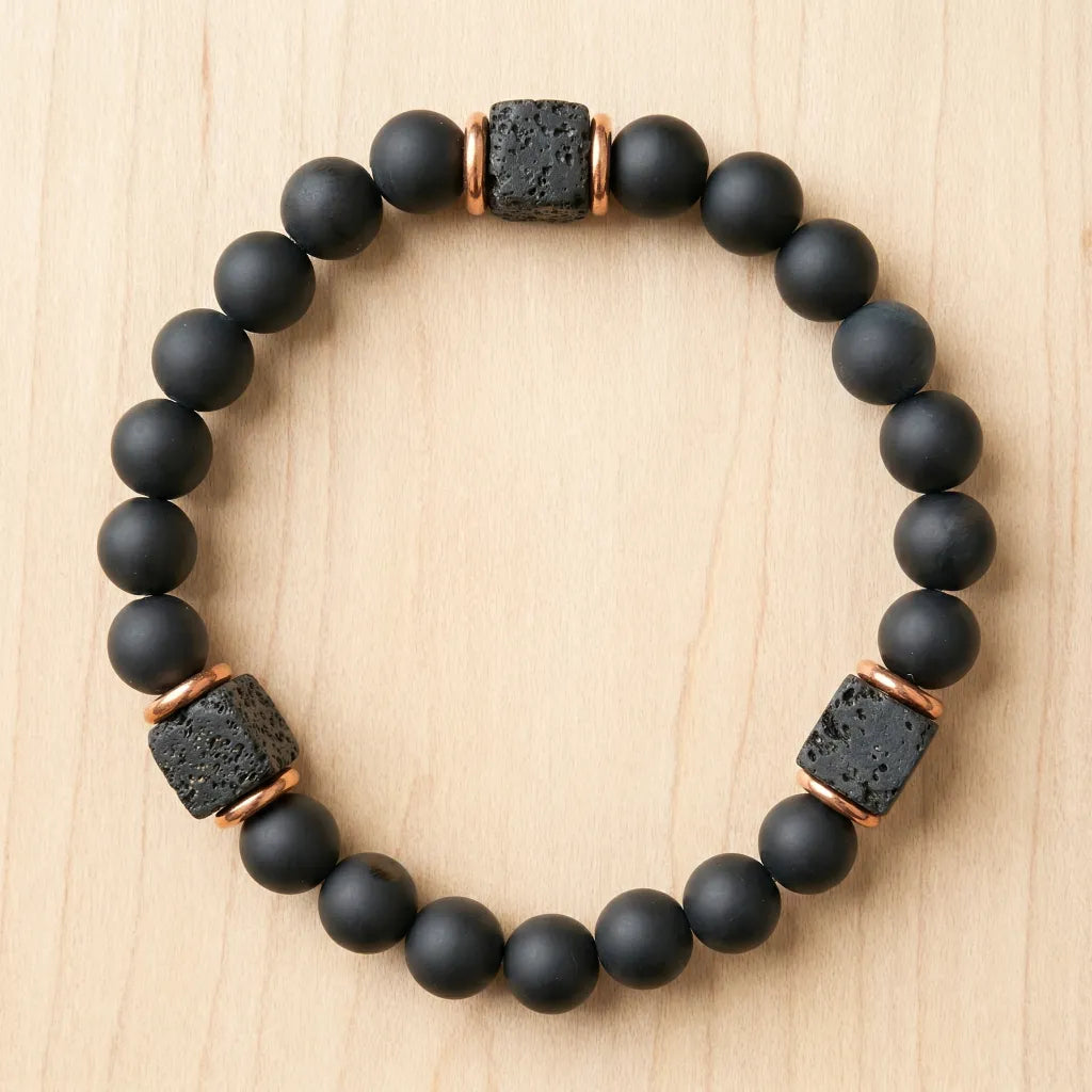 Onyx lava bracelet on light wood with matte black beads and lava stone spacers for grounding spiritual style
