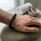 Onyx lava bracelet worn on wrist with matte black beads, grounding diffuser stone style calming energy for protection