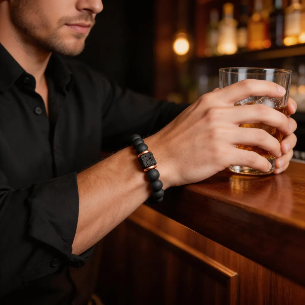 Man holding a glass of whiskey with a bar setting in the background