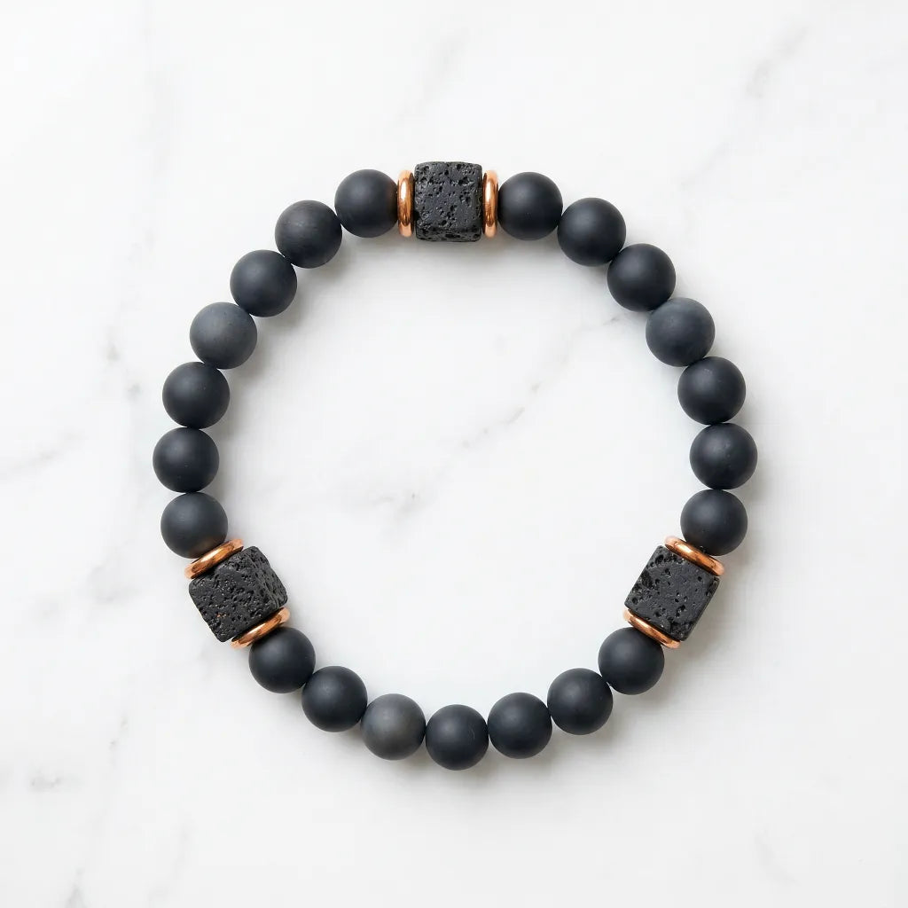 Onyx lava bracelet isolated on white marble, matte black beads with protective chakra energy and calm daily focus