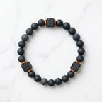Onyx lava bracelet isolated on white marble, matte black beads with protective chakra energy and calm daily focus