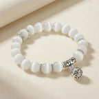 Moonlit Inspiration Opal Bracelet with polished white natural Opal beads, silver-tone details, and an ornate floral charm displayed as meaningful everyday gemstone jewelry in view.