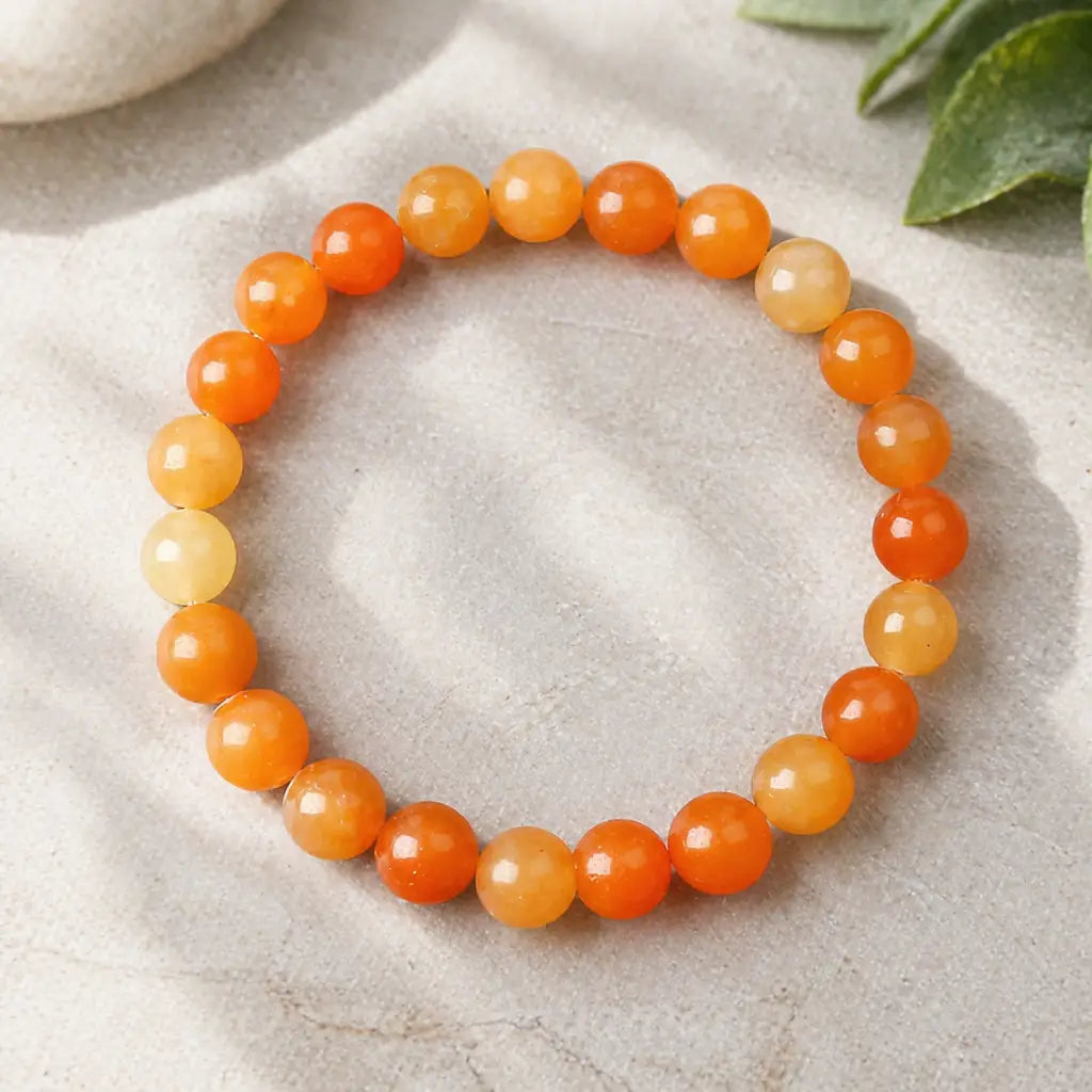 Orange aquamarine stone breacelet orange yellow bead bracelet on stone with leaves, uplifting crystal look today