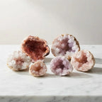 Pink amethyst geode assortment featuring natural crystal formations and sparkling quartz interiors for collectors and display enthusiasts.