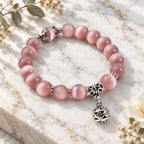 Pink Catseye bracelet with luminous pink beads, silver floral details and a dangling charm for graceful feminine style.