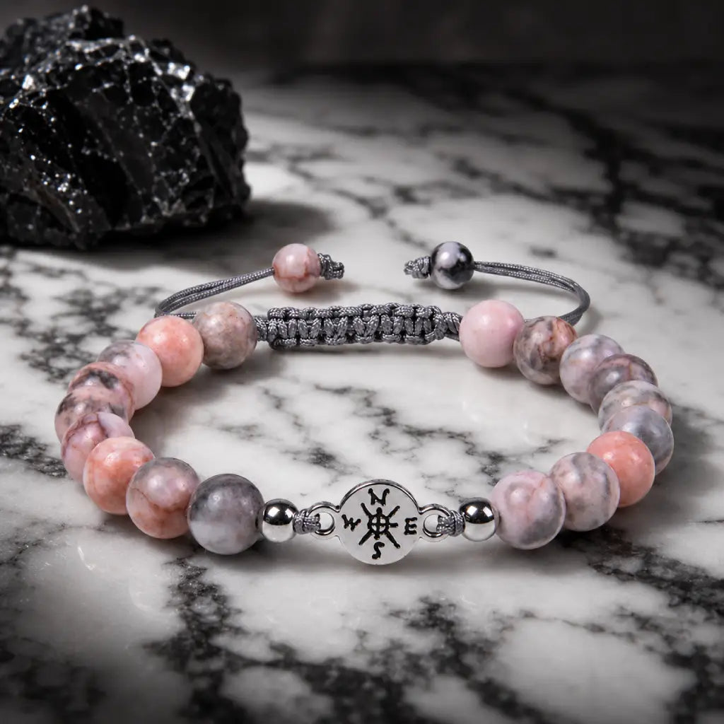 Pink Zebra Jasper crystal bracelet with glossy beads and silver charm on dark marble for luxury styling