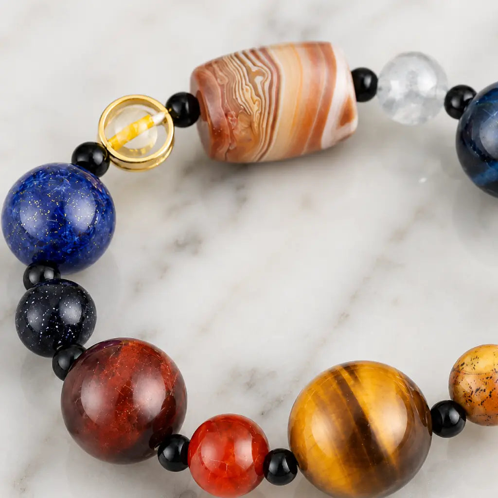 Planet bead tiger eye bracelet close-up showcasing polished tiger eye, striped agate centerpiece, quartz, and colorful gemstone beads with premium craftsmanship.
