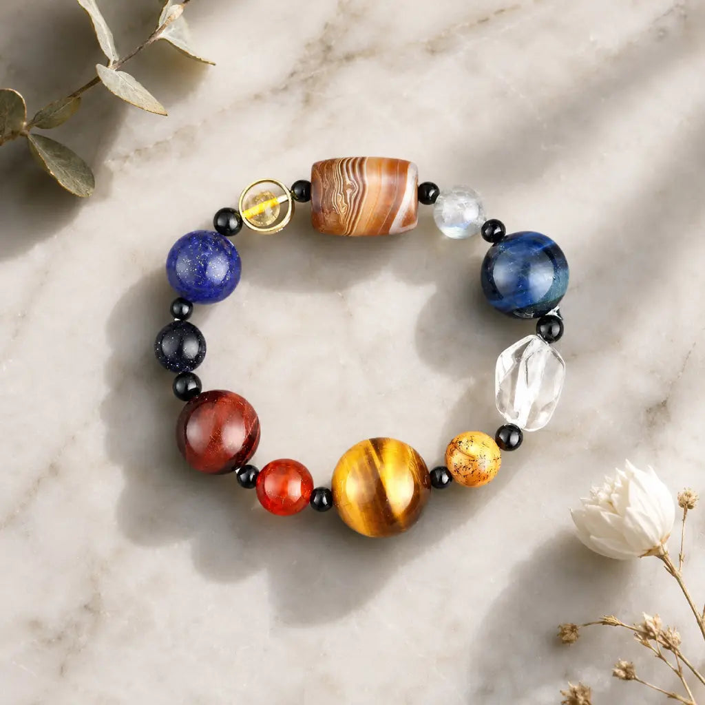 Planet bead tiger eye bracelet arranged in a minimalist flat lay with natural flowers, highlighting colorful gemstone beads and premium craftsmanship.