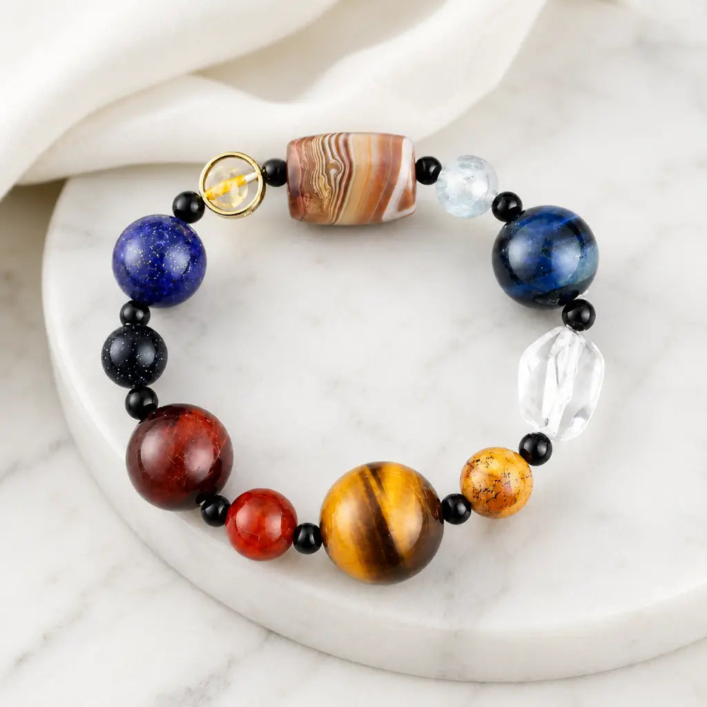 Planet bead tiger eye bracelet displayed on a marble pedestal with natural gemstone beads including tiger eye, quartz, lapis, and agate for elegant style.