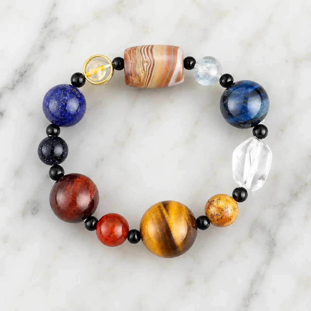 Planet bead tiger eye natural gemstone bracelet featuring polished tiger eye, quartz, agate, and colorful planet-inspired beads on a clean marble background.
