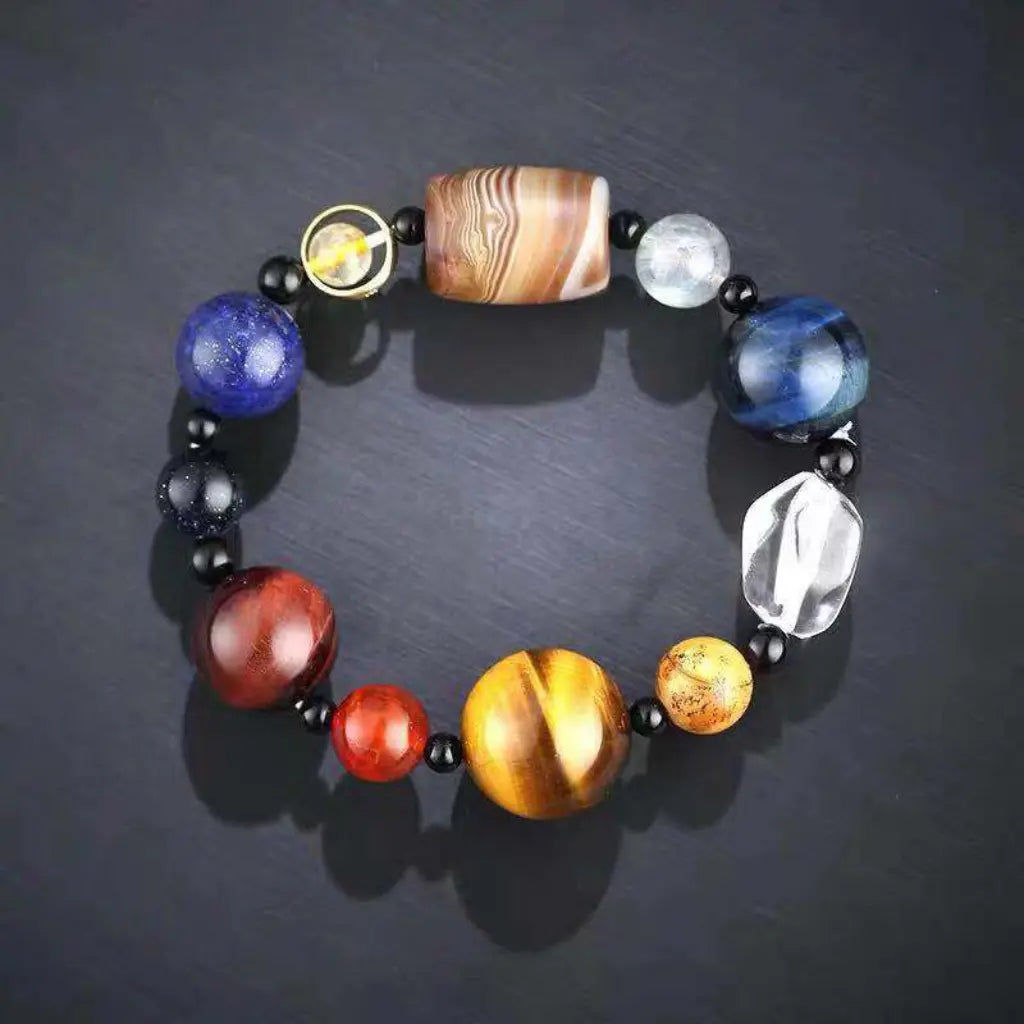 Planet bead tiger eye natural gemstone bracelet featuring polished tiger eye, quartz, striped agate, and colorful planet-inspired beads on a sleek black background.