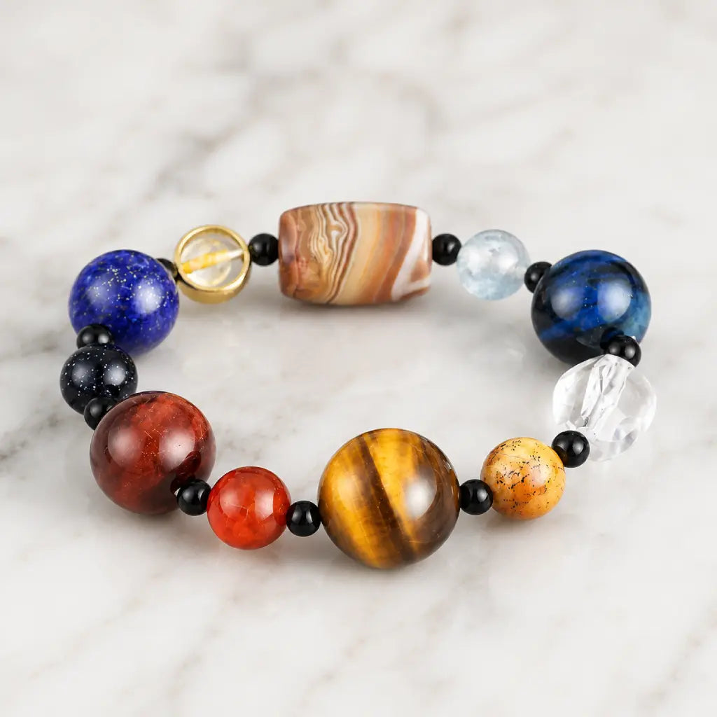 Planet bead tiger eye gemstone bracelet featuring colorful natural stone beads, polished tiger eye, quartz, and agate on a clean marble background.